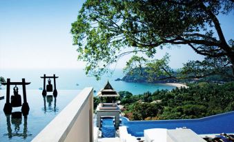 a beautiful swimming pool with clear blue water , surrounded by lush green trees and mountains in the background at Pimalai Resort & Spa