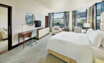 a hotel room with a king - sized bed , a flat - screen tv , a desk , and a chair at Hilton Windhoek