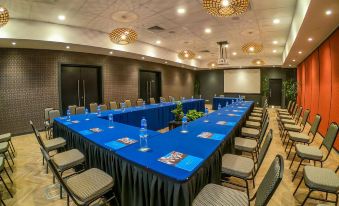 a large conference room with multiple rows of tables and chairs arranged in a semicircle at Highlander Hotel