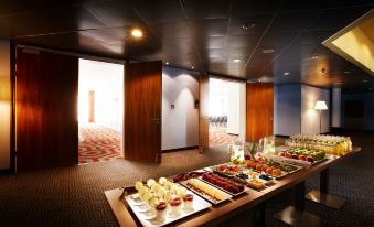 a buffet table filled with a variety of food items , including fruits , pastries , and other snacks at Pentahotel Wiesbaden