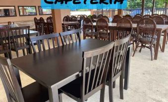 a cafeteria with a large table and chairs , some of which are in the process of being cleaned at Nks Chalet