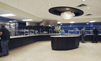 a modern restaurant with a large kitchen area featuring a black countertop and a blue display case at Jackpot Junction Casino Hotel