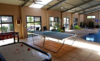 an indoor area with a pool table , ping pong table , and air hockey table in a large room at Streaky Bay Hotel Motel