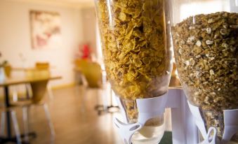 a table with a white shelf holding two containers filled with different types of cereal at Cherry Blossom Motor Inn