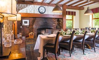 a dining room with a wooden table and chairs , along with a fireplace in the background at Blackwell House