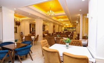 a large dining room with multiple tables and chairs arranged for a group of people at Hotel Empire Albania