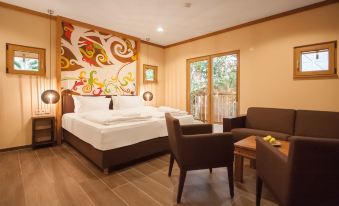 a hotel room with two double beds , a desk , and a chair , all decorated in a modern style at Tropical Islands