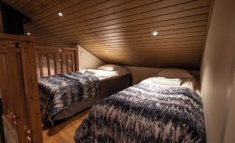 a room with two beds , one on top of the other , and a wooden floor at Ranua Resort Holiday Villas