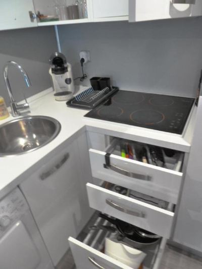 a small kitchen with white cabinets and a black electric stove , as well as a sink , stove , and microwave at Sun Studio