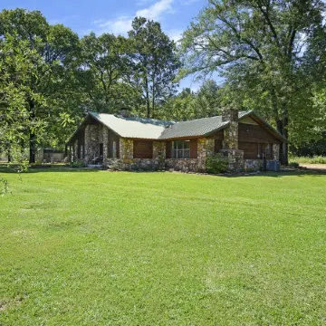 Secluded 4 bedroom farmhouse nestled on 8 acres with large lawn and oak trees.