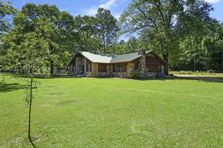 Secluded 4 bedroom farmhouse nestled on 8 acres with large lawn and oak trees.