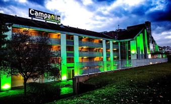 "a large building with a green sign that says "" campanile "" is lit up at night" at Campanile Marne la Vallee - Torcy