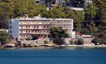 a large hotel situated on the edge of a body of water , surrounded by trees and buildings at Golden View
