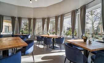 a large dining room with multiple tables and chairs arranged for a group of people to enjoy a meal together at Hotel Arborétum