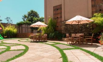 a courtyard with a stone pathway surrounded by chairs and umbrellas , creating a relaxing atmosphere at Nova Hotel