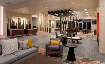 a modern lounge area with various seating options , including couches and chairs , in a spacious lobby at Running Aces Hotel & Casino Trademark Collection by Wyndham