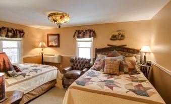 a cozy bedroom with two beds , one on the left and one on the right side of the room at Woodstock Inn, Station and Brewery