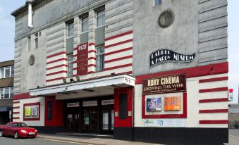 "a large red and white striped building with a sign that reads "" may cinema "" prominently displayed" at Premier Inn Ulverston