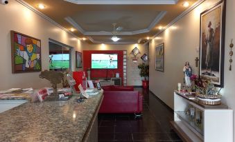 a room with a bar counter , a red couch , and a tv mounted on the wall at Hotel Boulevard