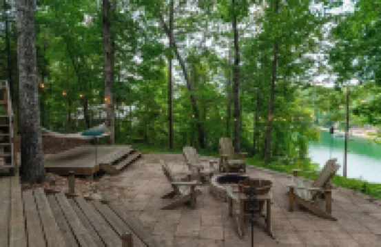 Luxurious cabin with fire pit, kayaks, and dock.