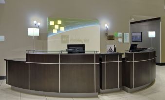 a reception desk in a hotel lobby with two computer monitors on either side of the counter at Holiday Inn Hammond