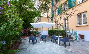 an outdoor dining area with a table , chairs , and an umbrella set up for guests to enjoy a meal at Hotel Geneva by Fassbind