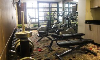 a well - equipped gym with various exercise equipment , including treadmills and stationary bikes , arranged in an indoor setting at Brentwood Suites