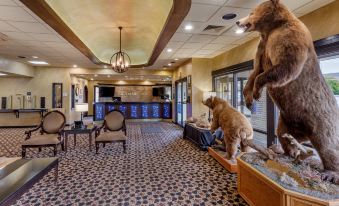 a room with a large stuffed bear on the wall and chairs around a counter at Best Western Dunmar Inn