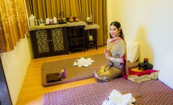 a woman in traditional attire sitting on a bed with robes and towels , giving a thumbs up at Mammoth Resort