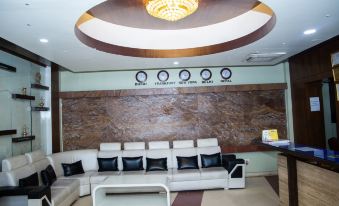 a modern living room with white and black furniture , a large ceiling light , and a marble wall mural at Hotel Samana