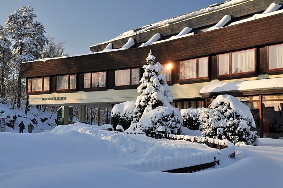 "a snow - covered building with the words "" hotel nadja "" on it , surrounded by trees and bushes" at Berghotel Bastei