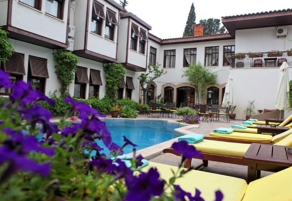 a courtyard with a pool surrounded by lounge chairs and tables , creating a relaxing atmosphere at Aspen Hotel