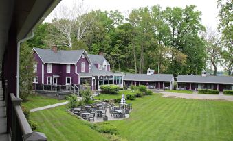 a large house with a purple exterior and a green lawn in front of it at Plum Point Lodge