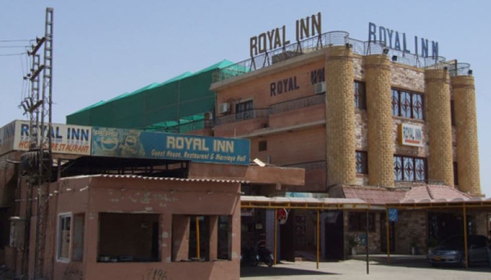 "a large hotel building with a sign that reads "" royal inn "" prominently displayed on the front of the building" at Royal Inn