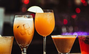 a bar with multiple glasses of drinks on the counter , including multiple glasses of orange juice and a variety of other beverages at Danfords Hotel & Marina