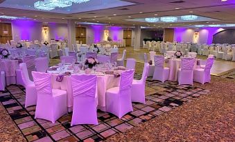 a well - decorated banquet hall with multiple tables covered in white tablecloths and chairs arranged for a formal event at Holiday Inn Clinton - Bridgewater