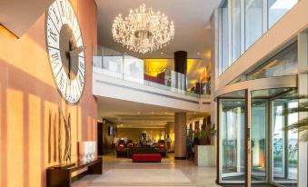 a large chandelier hangs from the ceiling in a modern building with an open area at Hotel Baia