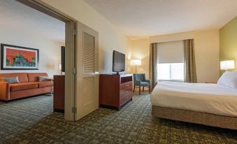 a hotel room with two beds , a tv , and a door leading to a balcony at Hilton Garden Inn Meridian