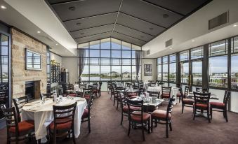 a large dining room with multiple tables and chairs arranged for a group of people to enjoy a meal at Quest Sanctuary Lakes