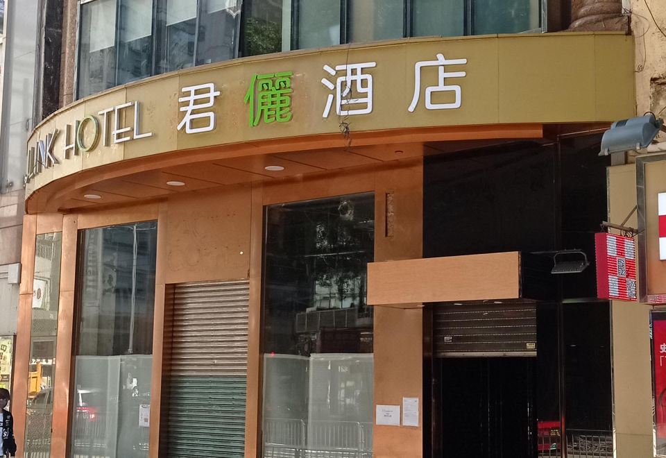 The front entrance of a restaurant is marked by an oriental sign, with another building nearby at J Link Hotel