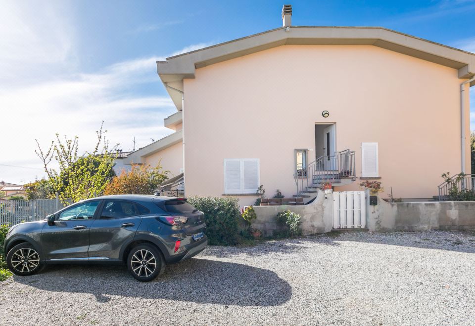 a car is parked in front of a house with a patio and stairs leading up to it at Mansarda