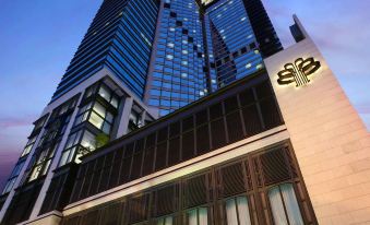 "A large building with a sign that says ""hotel"" in front and another sign" at Harbour Grand Hong Kong