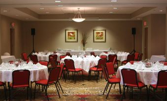 a large banquet hall with round tables covered in white tablecloths , set for a formal event at Holiday Inn Carbondale-Conference Center