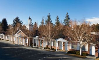 a row of buildings with trees in front and a parking lot in the foreground at Little America Hotel - Wyoming