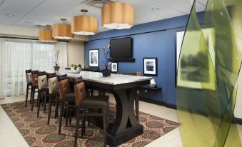 a room with a dining table and chairs , as well as a television mounted on the wall at Hampton Inn Lenoir City