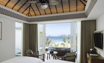 a bedroom with a view of the ocean through large windows , providing a serene and tranquil atmosphere at Banyan Tree Krabi