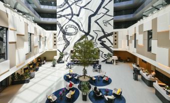 a modern hotel lobby with a large mural on the wall , creating an art installation at Mercure Geneva Airport