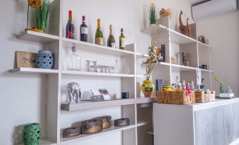 "a white room with shelves filled with various items and a counter featuring a shelf that says "" home "" on the left" at Nest