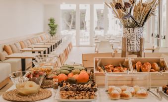 a long dining table filled with a variety of food items , including fruits , breads , and pastries at Hotel Neptuno
