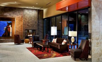 a hotel lobby with various seating options , including couches and chairs , as well as a television at Osage Casino Hotel